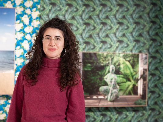 Cristina Pardo Porto stands in front of her curated exhibition, "Joiri Minaya: Unseeing the Tropics"