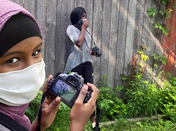 Rayan Mohamed (left) and Felone “Abigail” Nganga work on an assignment with their video cameras. Photo courtesy of Brice Nordquist.