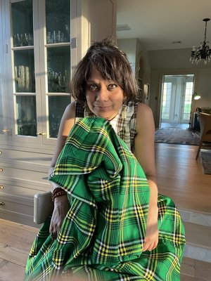 artist Rina Banerjee, clutches a bundle of green plaid material