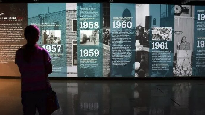 Museum-goer looking at digital timeline of history of civil rights.