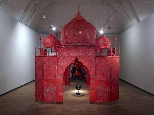 Rina Banerjee's large art installation, a reddish pink construct called "Take Me to the Palace of Love"