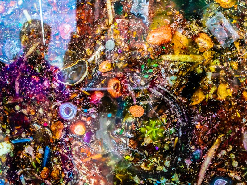 art exhibit in NYC of a fish tank full of litter found along the bottom of the Hudson River